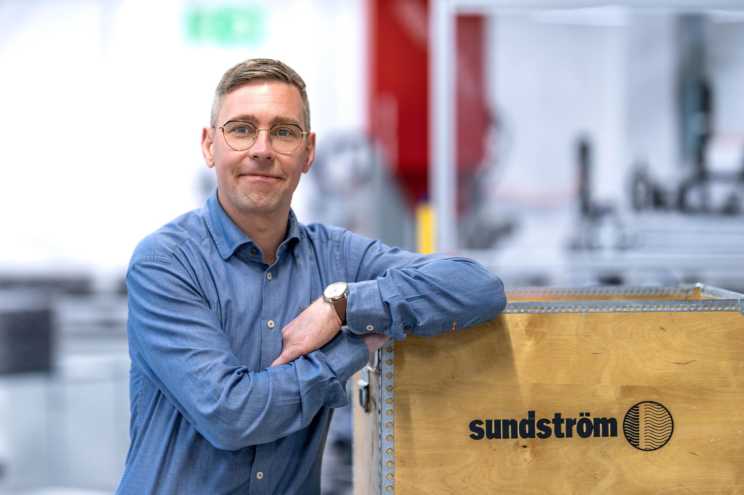 Man in a blue shirt standing in the factory